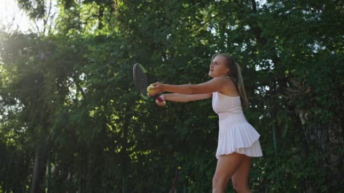 女运动员发球并在网球场上跳球