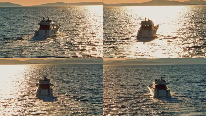 当太阳落在岛屿后面时，空中游艇在海上航行