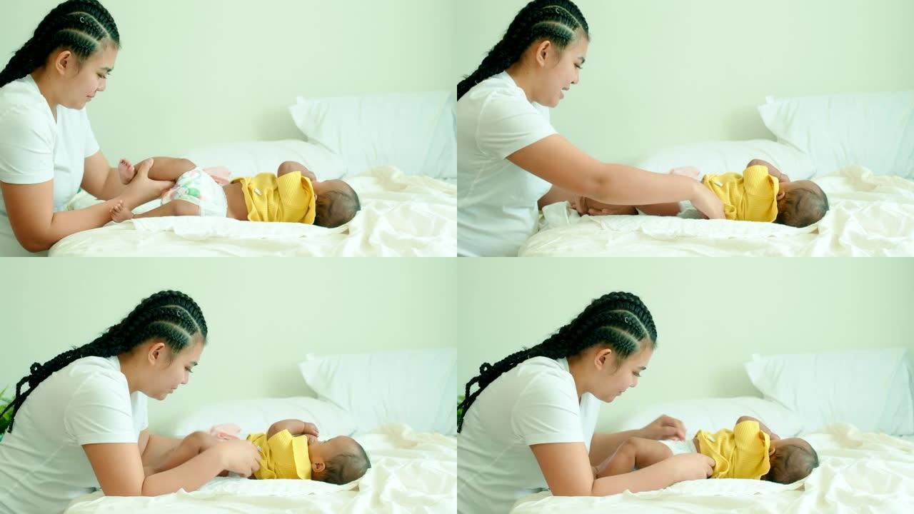 年轻的单身母亲在卧室里换尿布。