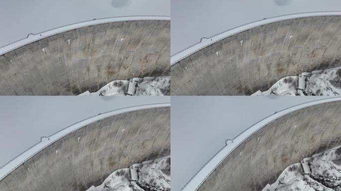 空中无人机拍摄的一名男子穿越山区积雪覆盖的大坝