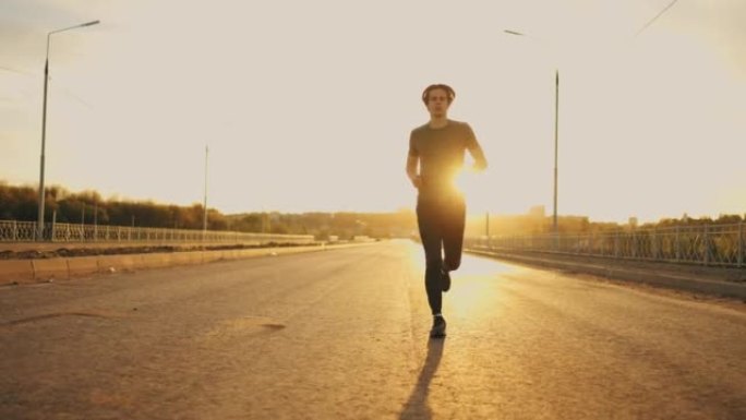 英俊的运动员在夏天的早晨在空旷的道路上独自奔跑，男性形象
