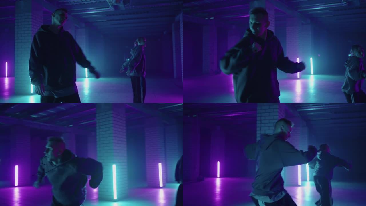 两位霓虹灯中的嘻哈舞者以蓝色和紫色一起跳舞。在黑暗的工作室里享受嘻哈动作的女性，有烟雾和灯光。