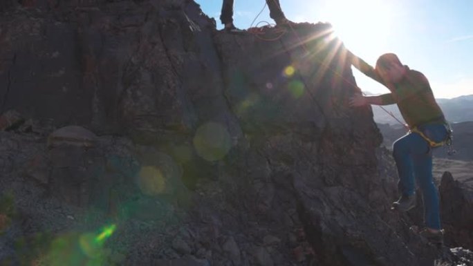 登山者使用绳索，装备登上山顶