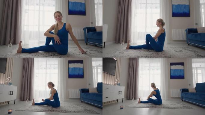 年轻女子在家练习瑜伽，以简单的身体姿势放松，坐在地板上，周围有漂亮的家具。穿着运动服的苗条女人跪在地
