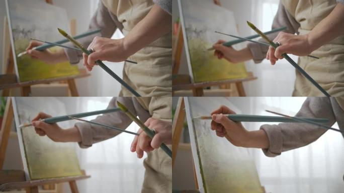 风景画家在工作室工作，用刷子和油染料绘画，用图像在画布上特写视图