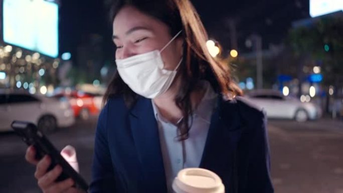 亚洲女商人使用平板电脑，她在城市散步时喝咖啡。