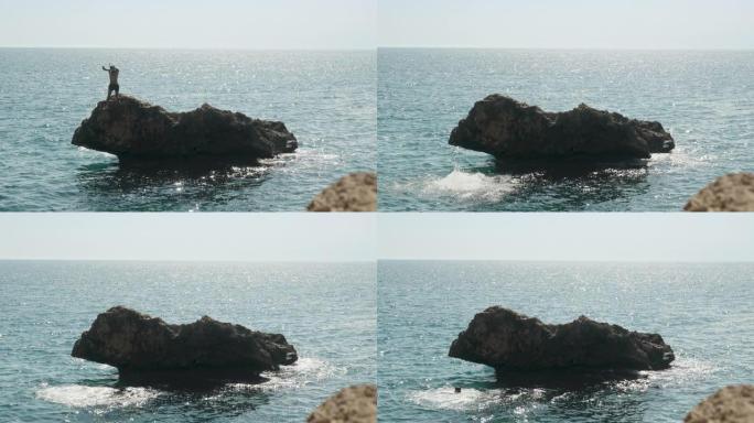一个蒙面人从站在海里的悬崖上跳下。