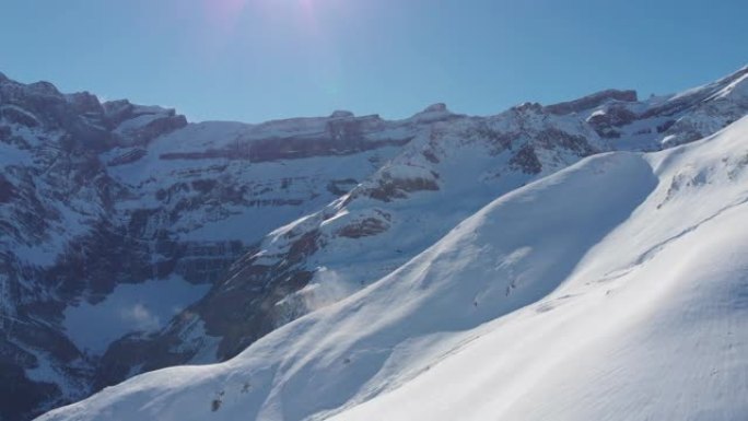 在晴朗的日子里，空中无人机拍摄了白雪皑皑的山坡