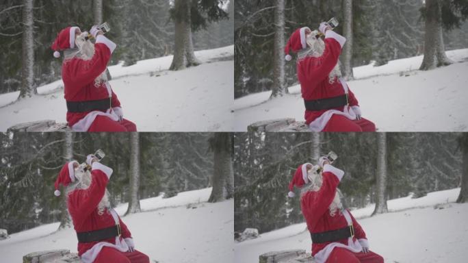 男子打扮成圣诞老人，从雪林的树桩上的瓶子里喝酒