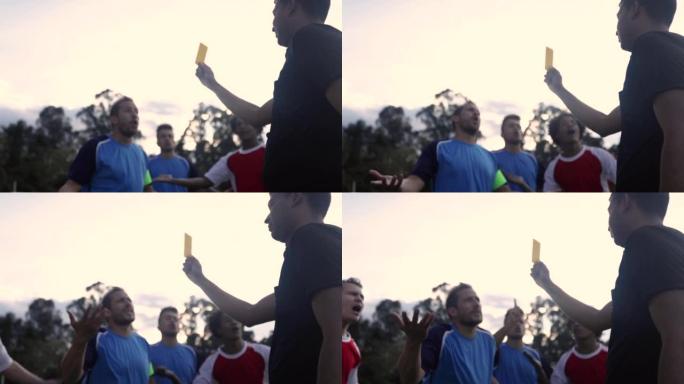 足球运动员在比赛中举起黄牌时与裁判争吵