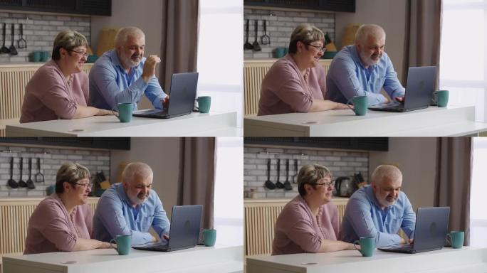 老父母正在通过笔记本电脑通过视频通话与孩子聊天，老男人和女人坐在厨房里，看着网络摄像头