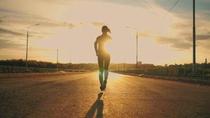 女跑步者在日落时间独自在户外奔跑，运动的女人在灿烂的阳光下