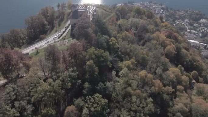 空中无人机拍摄了俯瞰湖泊和山脉的树木繁茂的山顶