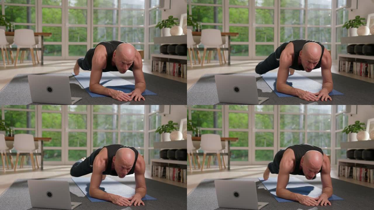 运动员在家庭锻炼时做木板运动。使用笔记本电脑