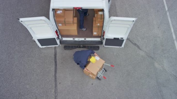 CS两名送货员将包裹从手推车装载到货车中