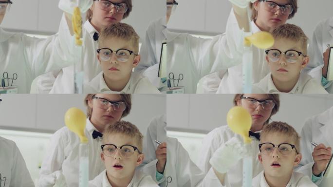 在实验室学习的男孩。玩得开心，用充满气体的气球做实验