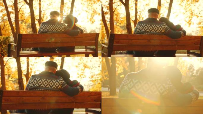 没有脸背射。高级夫妇在公园享受日落，坐在阳光下的长凳上。秋叶颜色。大自然的美