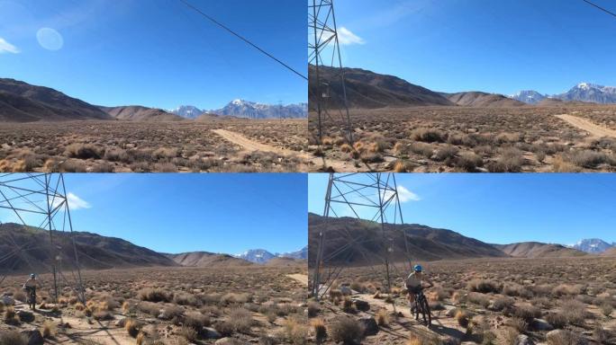 女山地自行车跟随狭窄的沙漠轨道，在动力塔下