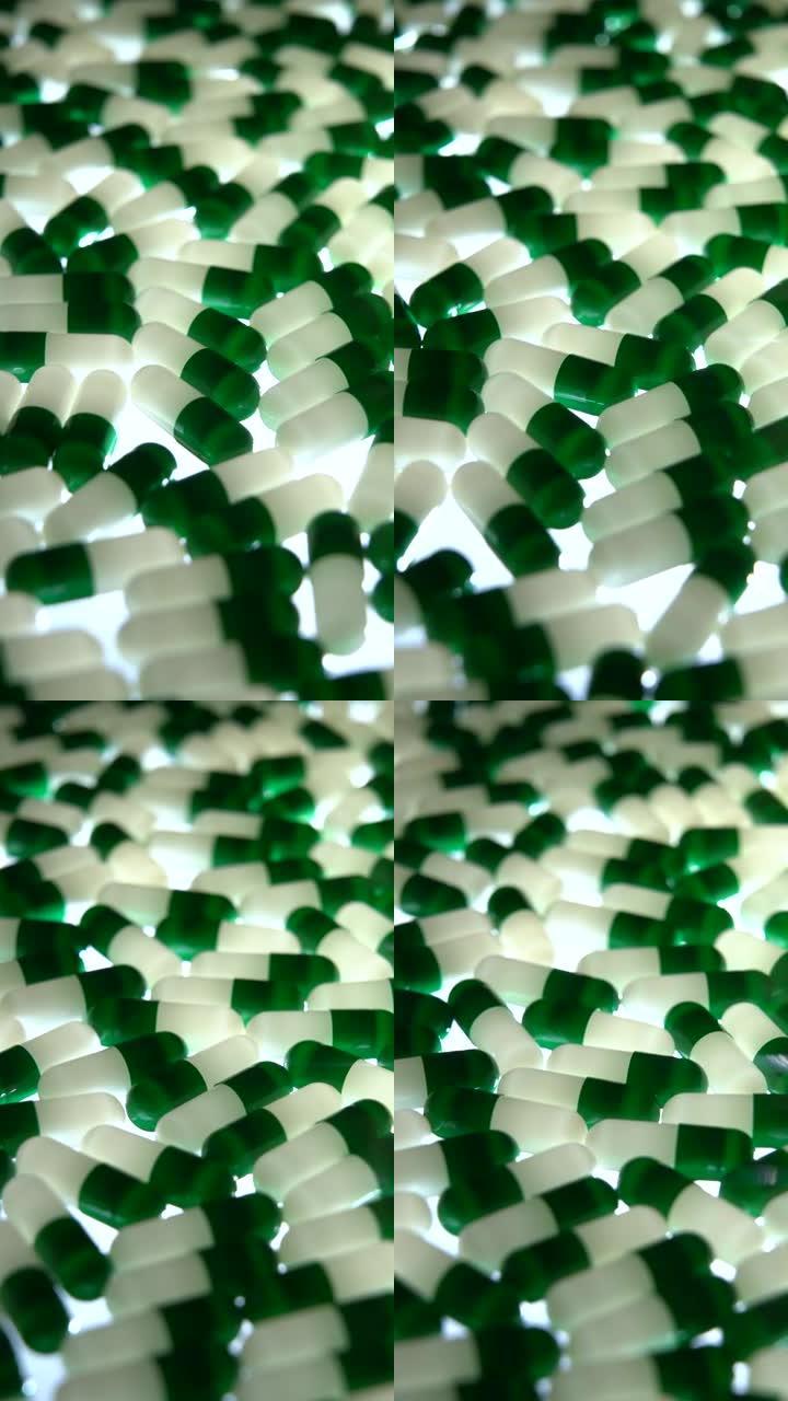 垂直: 绿色和白色胶囊药丸旋转，黑色照明