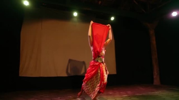 穿着红色传统服装跳舞时，红色衣服遮住了女人的脸