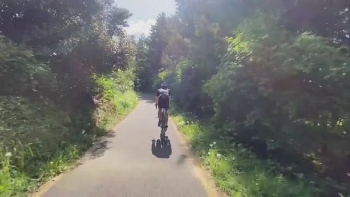 在树林里的一条小路上骑自行车的人的镜头之后