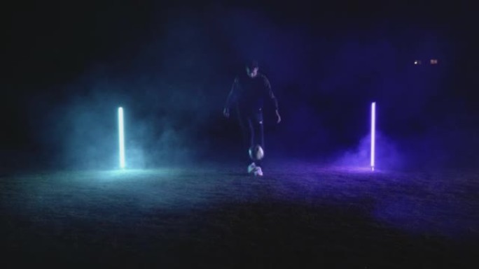 足球运动员用霓虹灯对黑色进行技巧