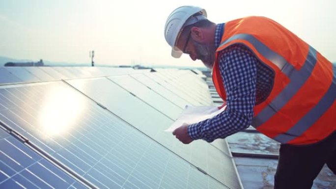 TS男工程师检查屋顶太阳能发电厂的光伏电池板