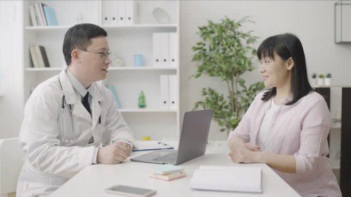 男性妇科医生在诊所咨询亚洲患者，女性保健服务