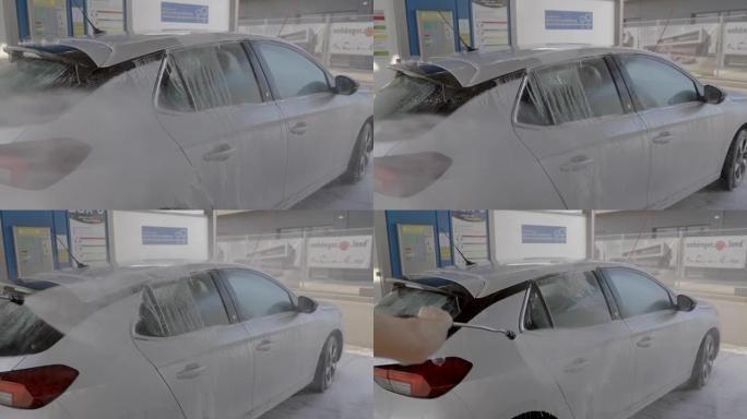 一名男子在洗车场用肥皂水洗车