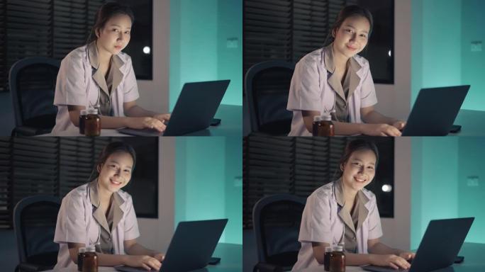 使用笔记本电脑微笑的年轻医护人员的肖像