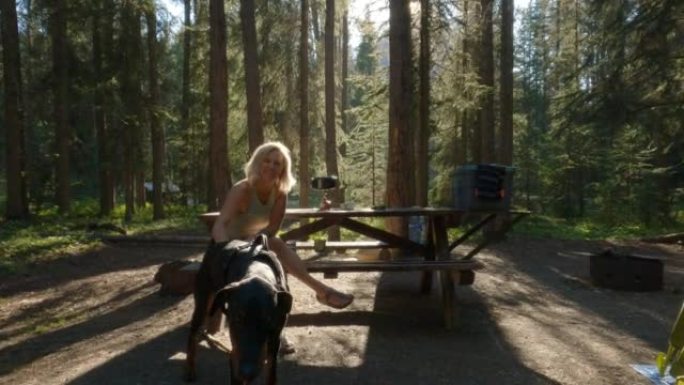 女人喜欢在森林露营地与宠物狗一起露营
