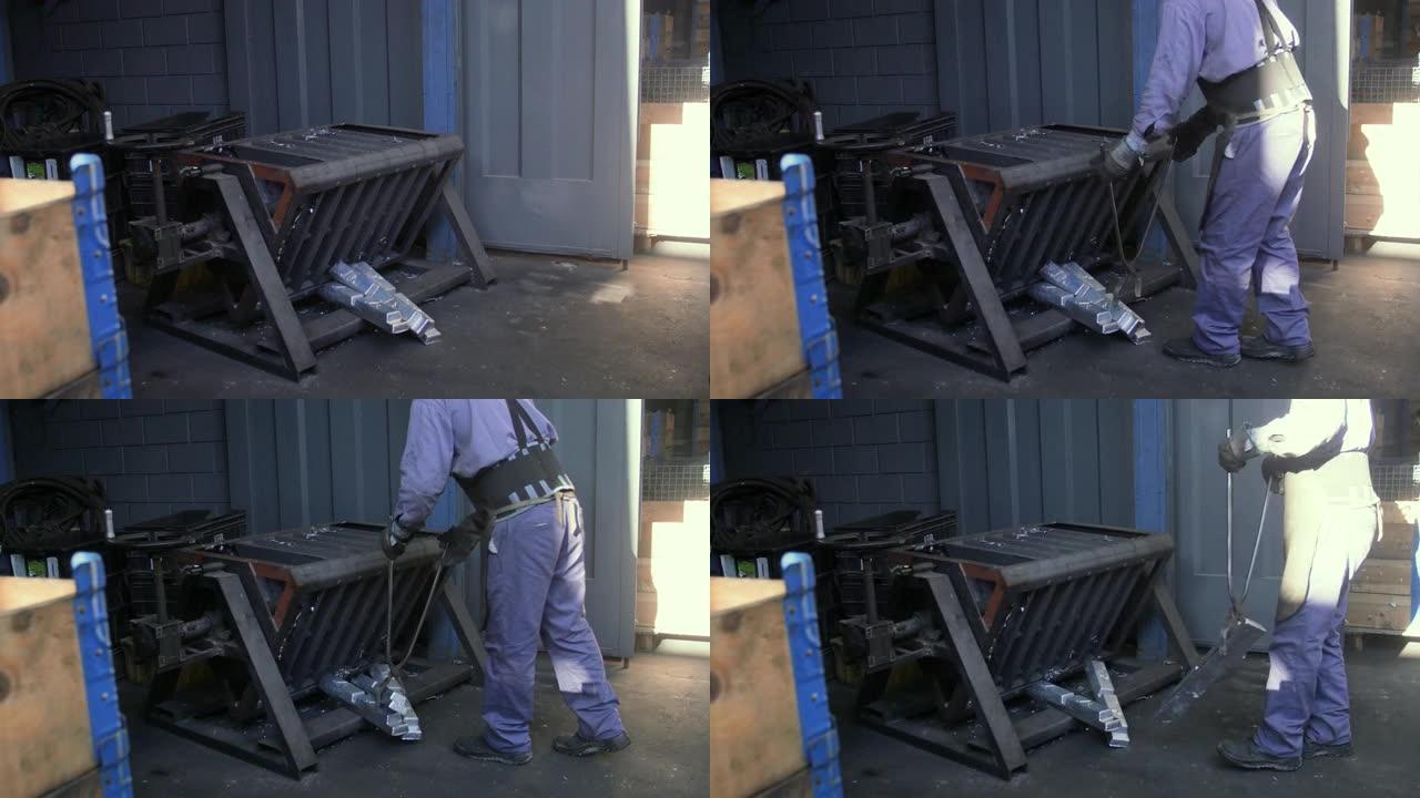 无法识别的蓝领工人使用工具将金属片从一个地方移动到另一个地方
