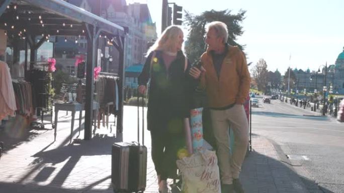 成熟的夫妇带着旅行行李探索维多利亚海滨街