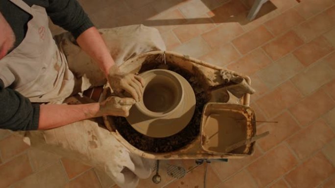 CS男性陶工在旋转的陶工轮子上创造一个碗