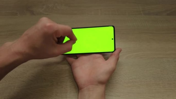 Hands of a young man signs the phone screen Green 