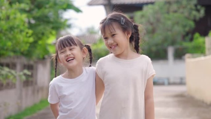两个年轻的亚洲女孩在自然环境中灿烂地微笑。