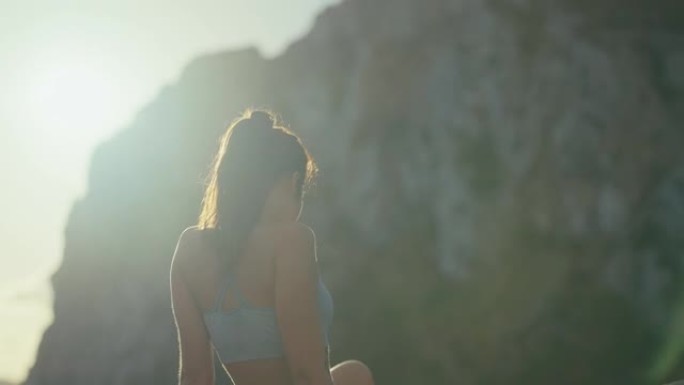 自然界的自由。美丽的年轻女子欣赏美丽的山景，在草地上休息