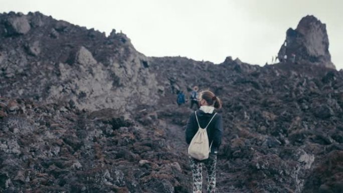 山之旅。沿着山路散步的女人。背景朋友。干旱气候