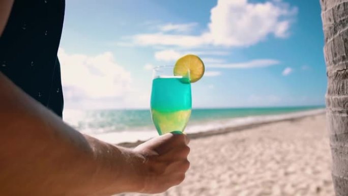 一个男人在海滩上喝酒的细节镜头