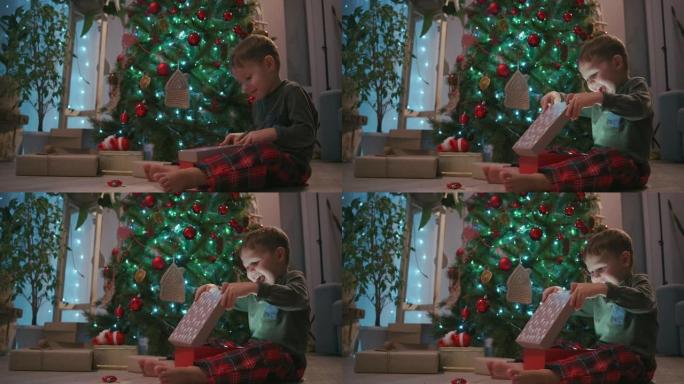 男孩打开礼物，盒子里的光照亮了快乐的脸。在树下打开礼物