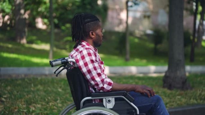 非裔美国残疾人坐在轮椅上，感到孤独