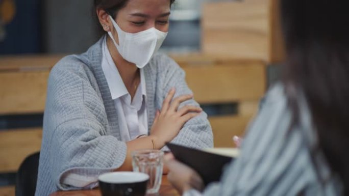 亚洲女性私人银行家在咖啡店里与女性交谈