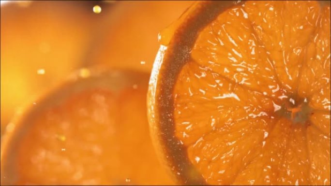 一滴橙汁从成熟多汁的橙片表面流下。慢动作4K