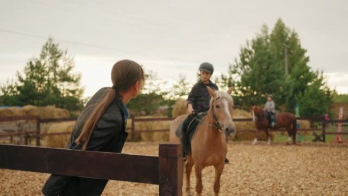 小女孩的马术运动训练，孩子坐在小马背上，教练女人正在解释