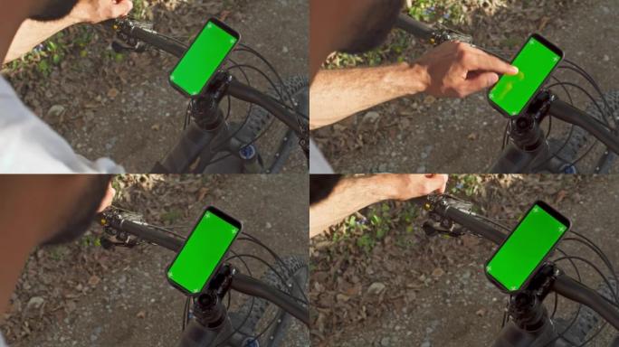 男子按下山地自行车车把上智能手机的屏幕