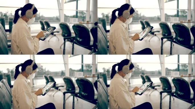 女乘客在登机时播放等候的平板电脑。在出发航站楼