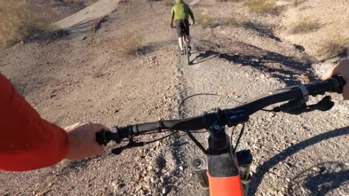 沿着沙漠小径骑e山自行车的第一人称视角