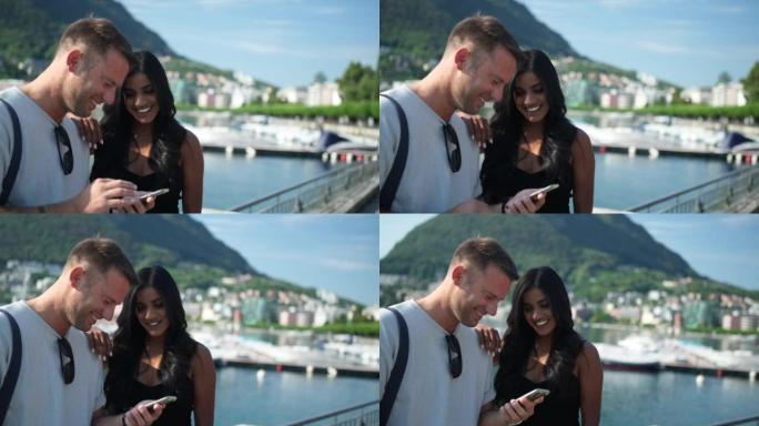 男人和女人在使用智能手机时微笑