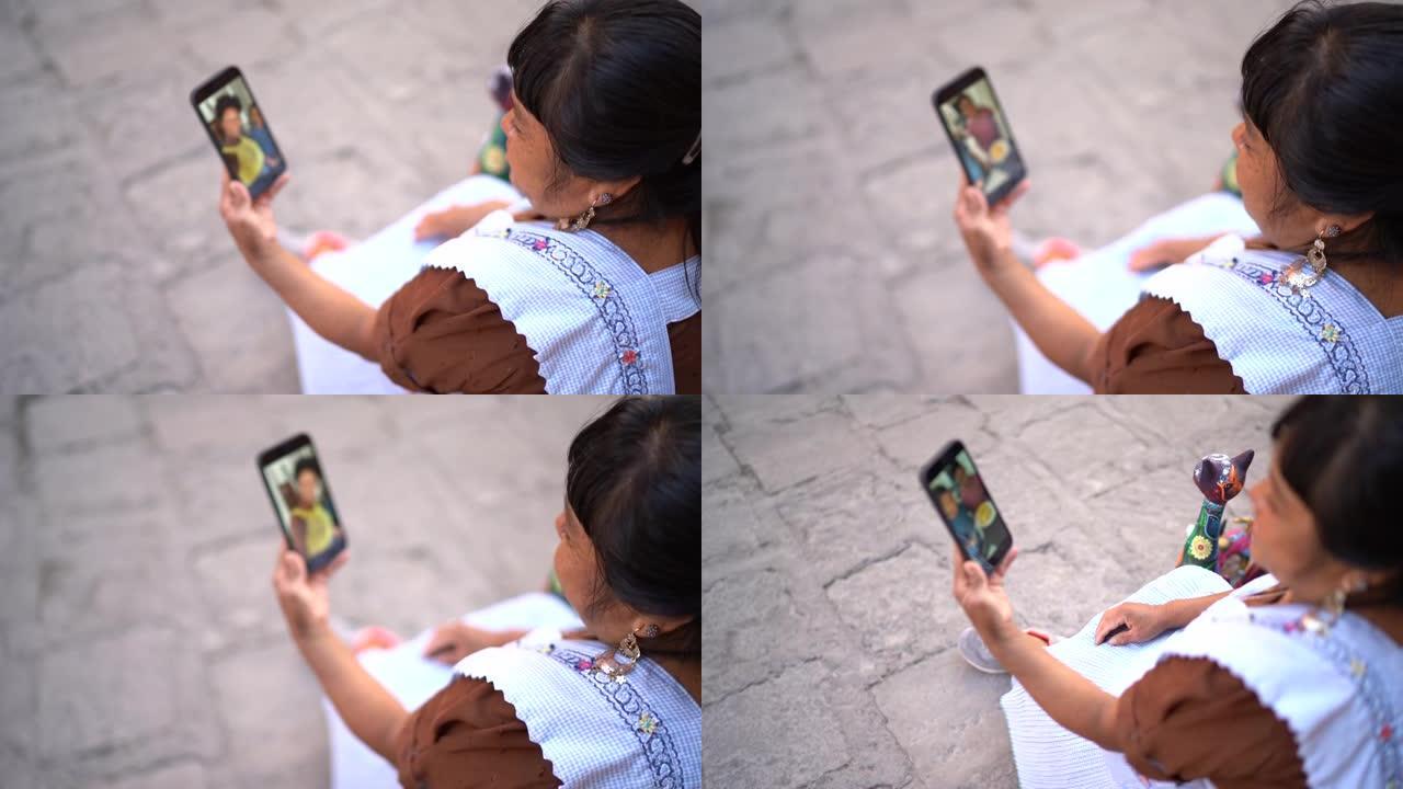 街头成熟的女人在智能手机上进行视频通话