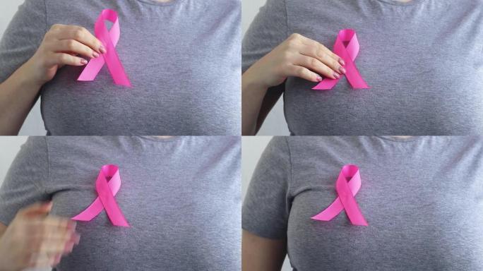 乳腺癌宣传月。女子手里拿着粉红色的丝带。支持和帮助的概念。